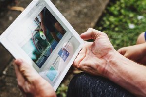 an arm holding a tablet with educational video about tennis