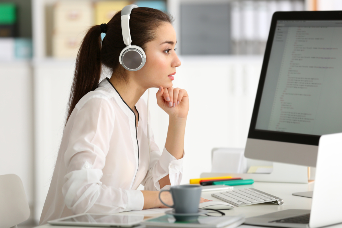 woman wearing headphones using computer