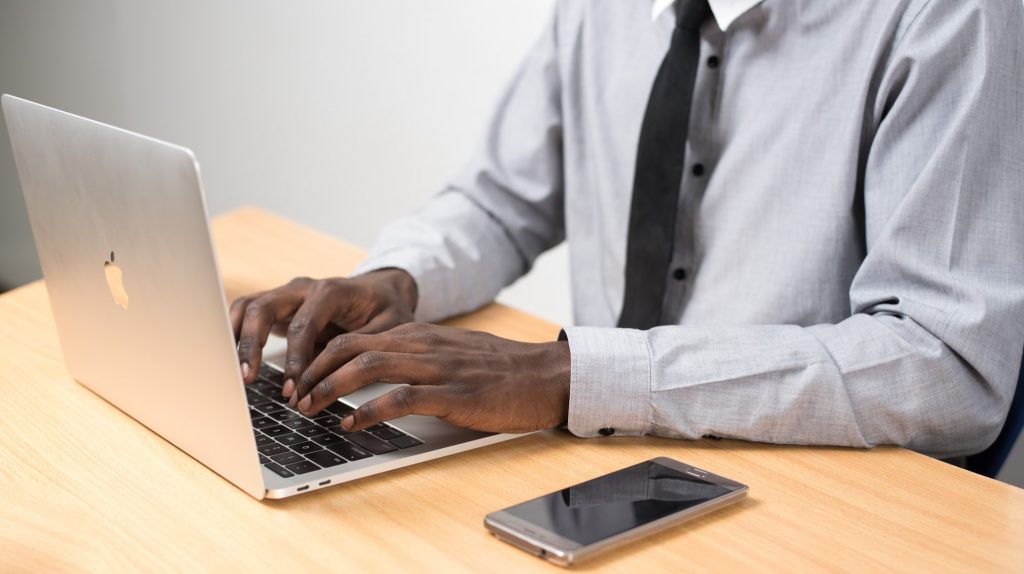 Expert from human transcriptionist services typing on laptop